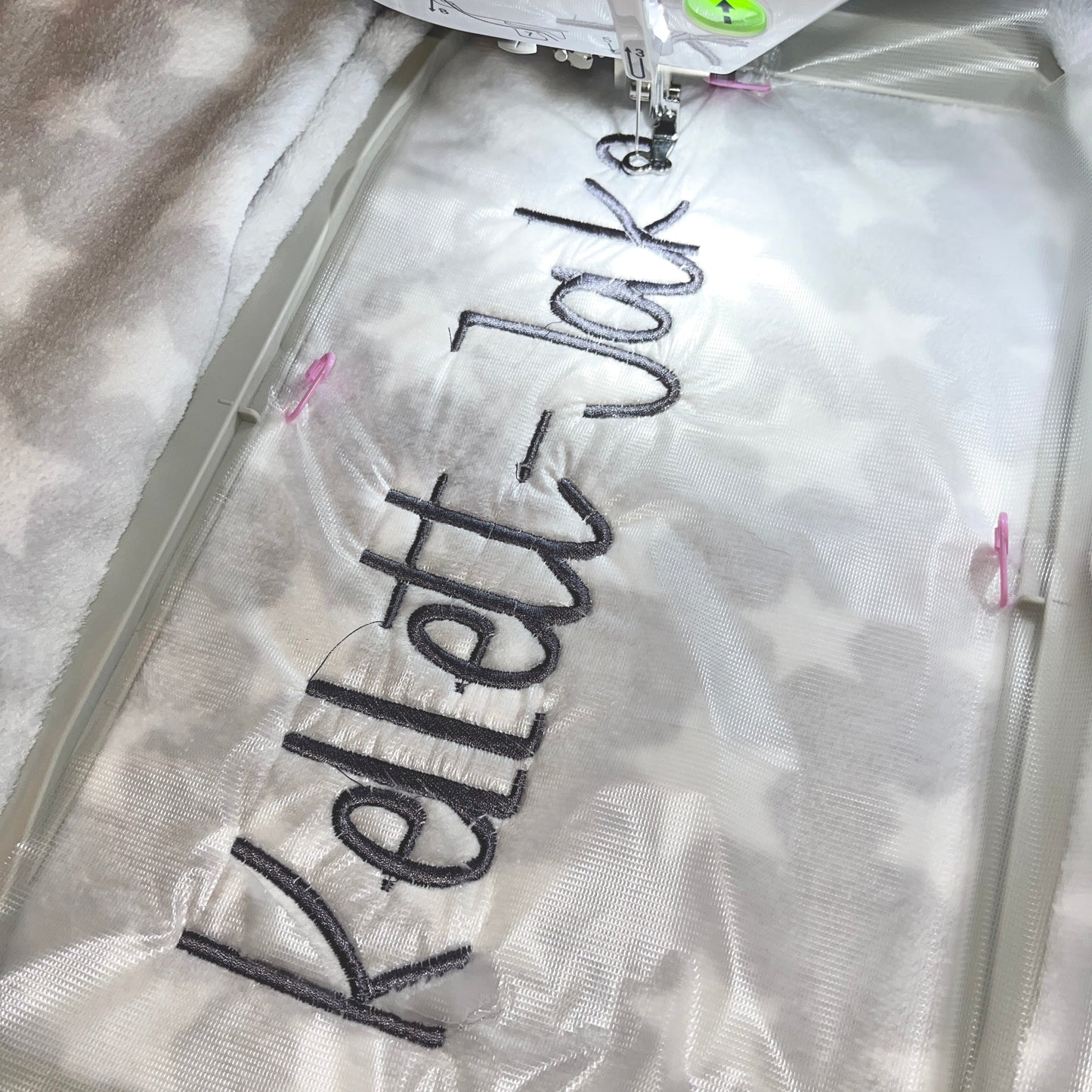 Grey baby blanket with a name embroidered on it