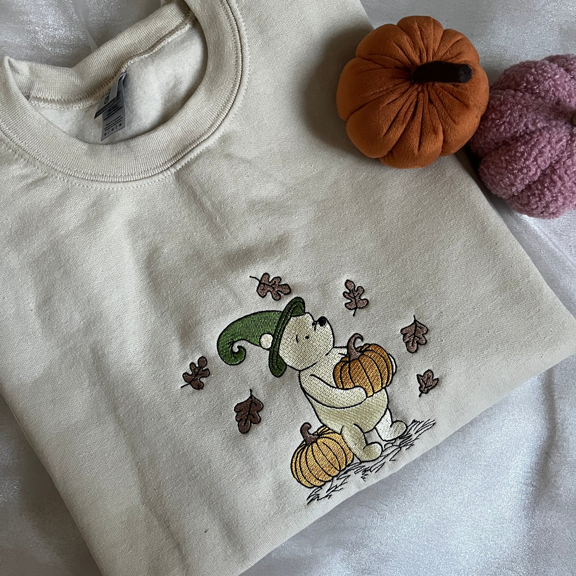 Beige sweatshirt with embroidered design of a bear with pumpkins
