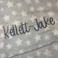 Grey baby blanket with a name embroidered on it