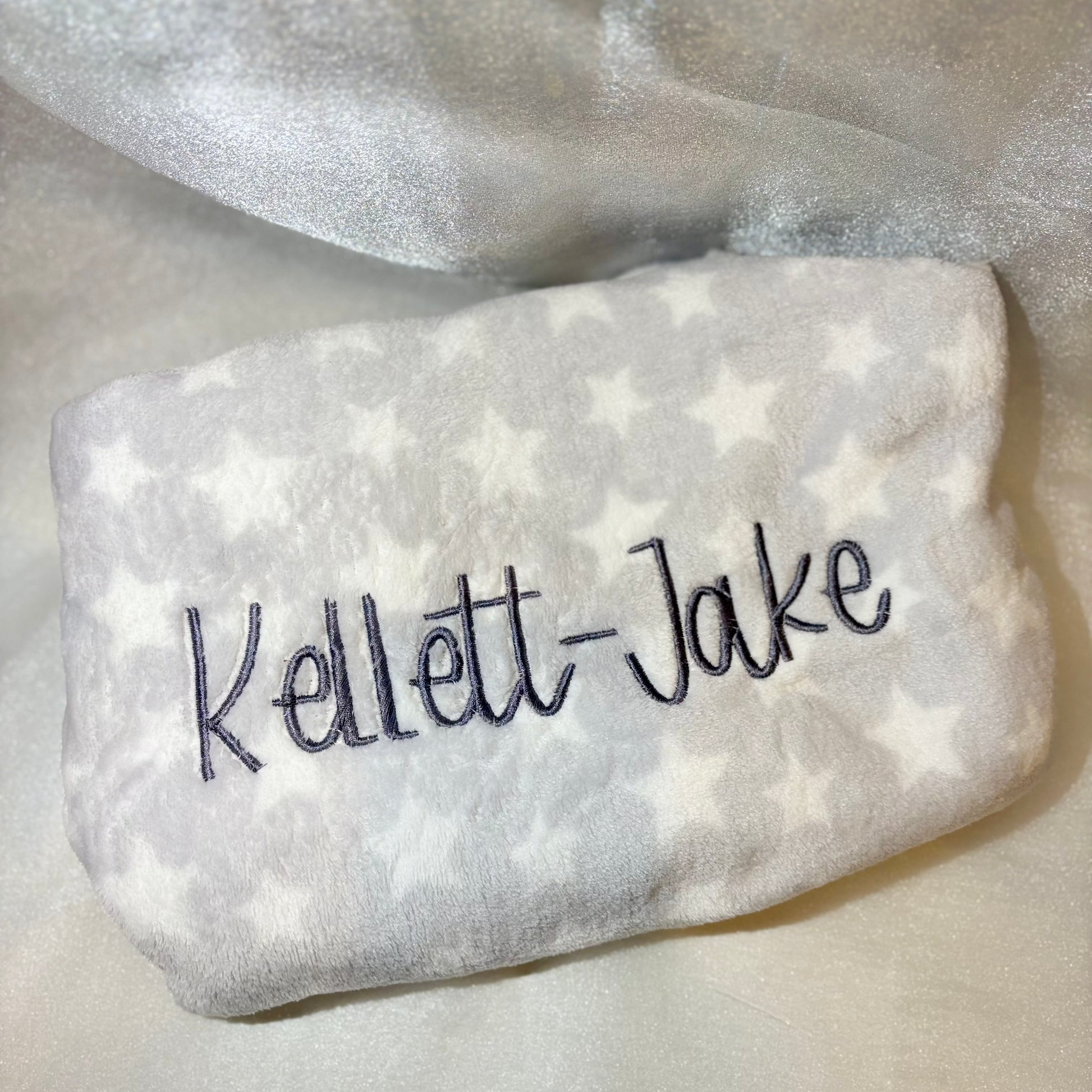 Grey baby blanket with a name embroidered on it
