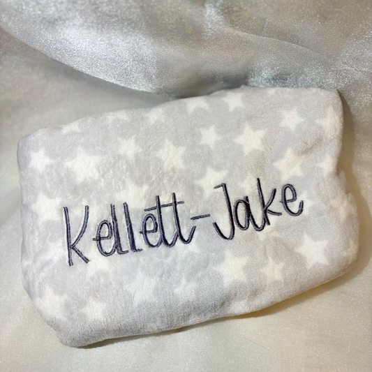Grey baby blanket with a name embroidered on it
