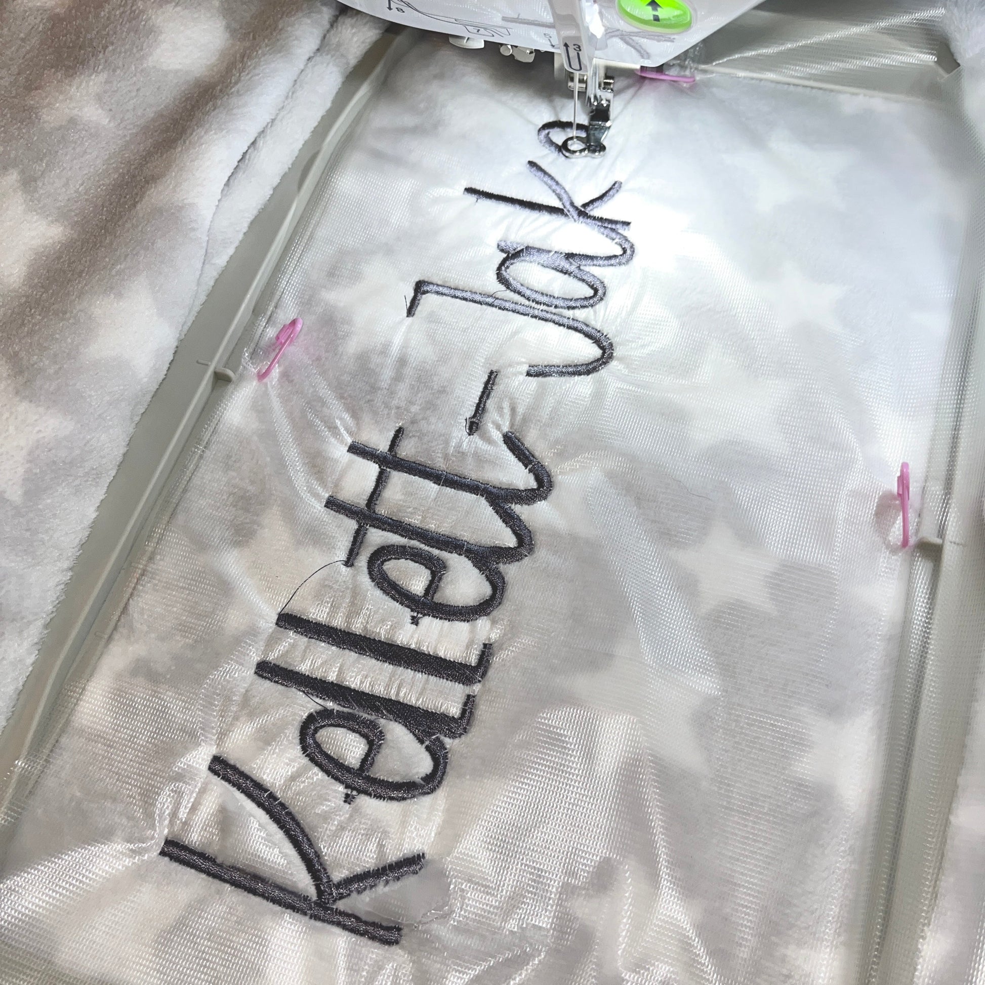 Grey baby blanket with a name embroidered on it