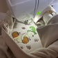 Close-up of a beige embroidered sweatshirt of a  cartoon bear and pumpkin design