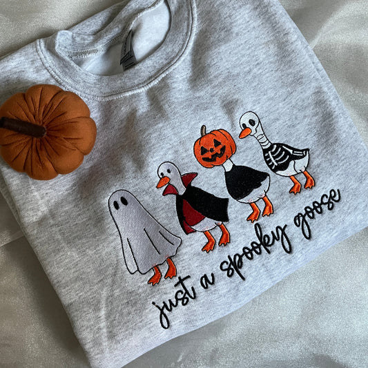 Gray sweatshirt with Halloween-themed design on a light gray background